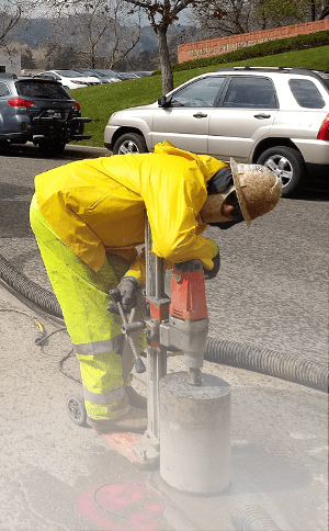 a worker uses equipment to fix potholes