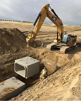 utility containers being dropped into a trench